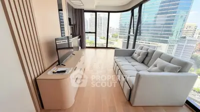 Modern living room with large windows and city view, featuring a sleek sofa and entertainment unit.