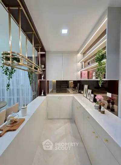 Elegant modern kitchen with sleek white cabinetry and stylish gold accents, perfect for contemporary living.