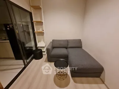 Cozy living room with modern gray sofa and stylish decor in a compact apartment.