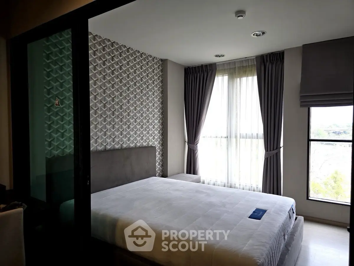 Modern bedroom with stylish textured wall and large window for natural light