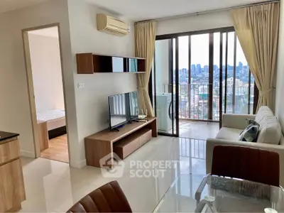 Modern living room with city view and balcony access in high-rise apartment.