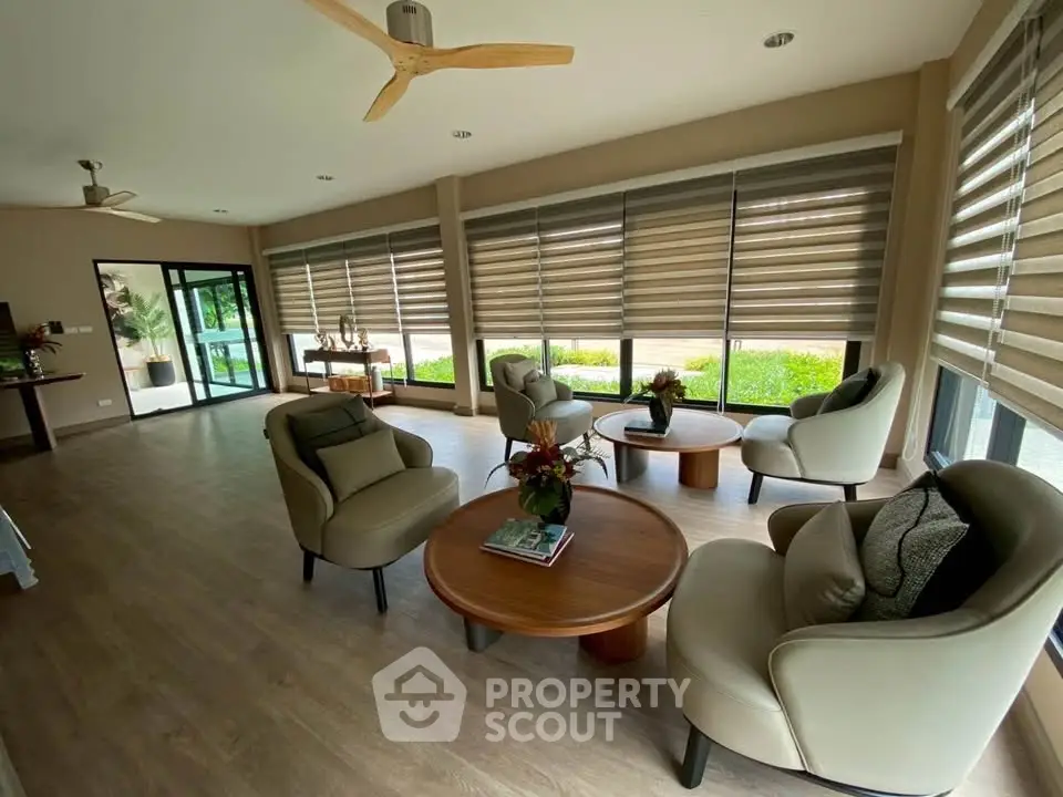 Spacious modern living room with elegant furniture and large windows.