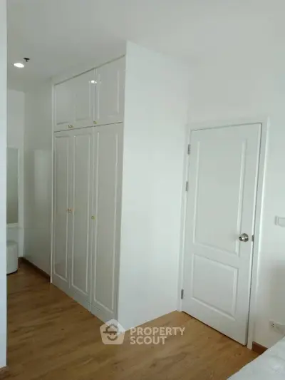 Modern bedroom with built-in wardrobe and wooden flooring