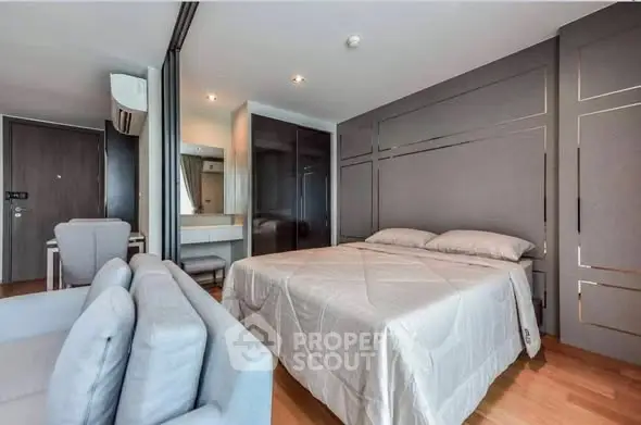 Modern bedroom with stylish decor and comfortable seating area in a contemporary apartment.