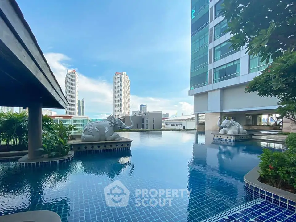 Luxurious rooftop pool with city skyline view and elegant sculptures.