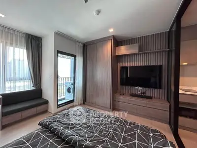 Modern bedroom with balcony and built-in TV unit in a stylish apartment.