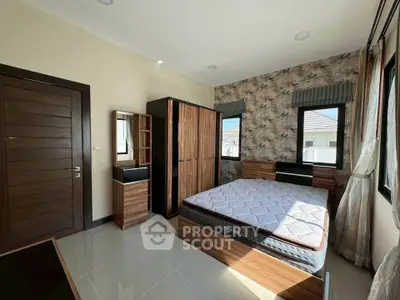 Spacious bedroom with modern furniture and large windows for natural light.