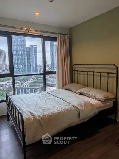Modern bedroom with large window offering stunning city view in high-rise apartment