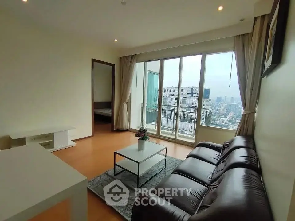 Spacious living room with city view and modern furnishings in high-rise apartment.