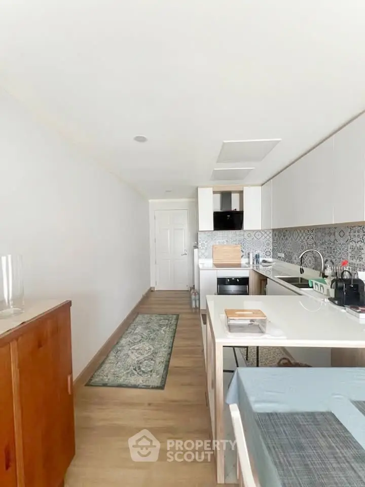 Modern kitchen with sleek cabinetry and stylish backsplash in a bright, open layout.