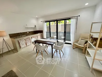 Modern open-layout living room with dining area and balcony access, featuring sleek furniture and natural light.