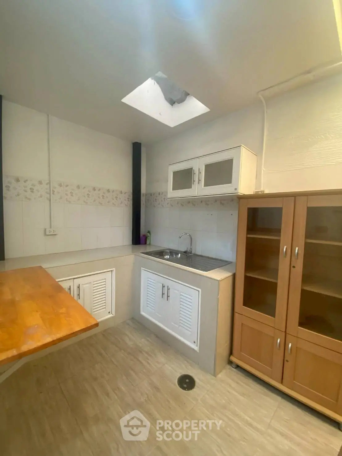 Charming kitchen with skylight and wooden cabinetry in cozy home