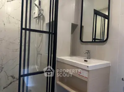 Modern bathroom with sleek shower and stylish vanity in contemporary apartment.