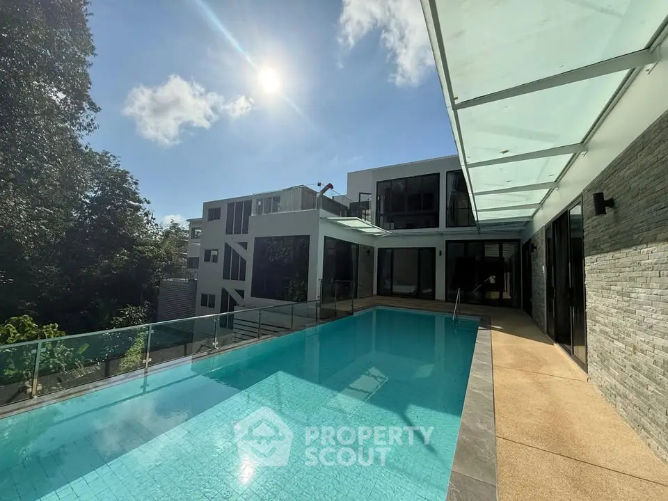 Luxurious modern home with stunning pool and sleek architecture under a bright sky.
