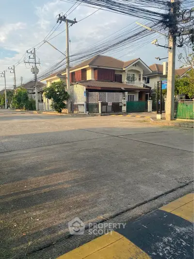 Charming two-story house with a warm wooden facade, nestled in a tranquil neighborhood, offering a spacious corner lot with ample street frontage.