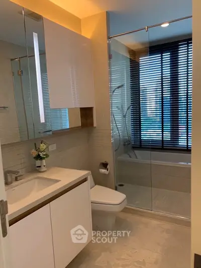 Modern bathroom with glass shower and sleek fixtures in luxury apartment