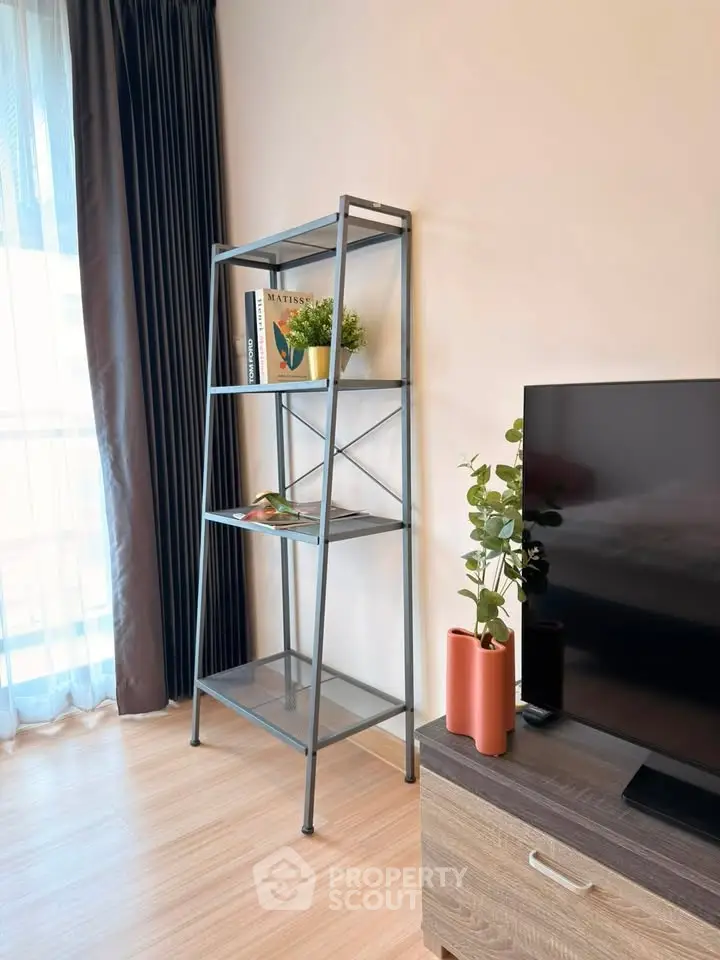 Modern living room with sleek metal shelf and large TV, perfect for stylish urban living.