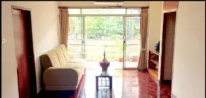 Spacious living room with large windows and polished wooden floors