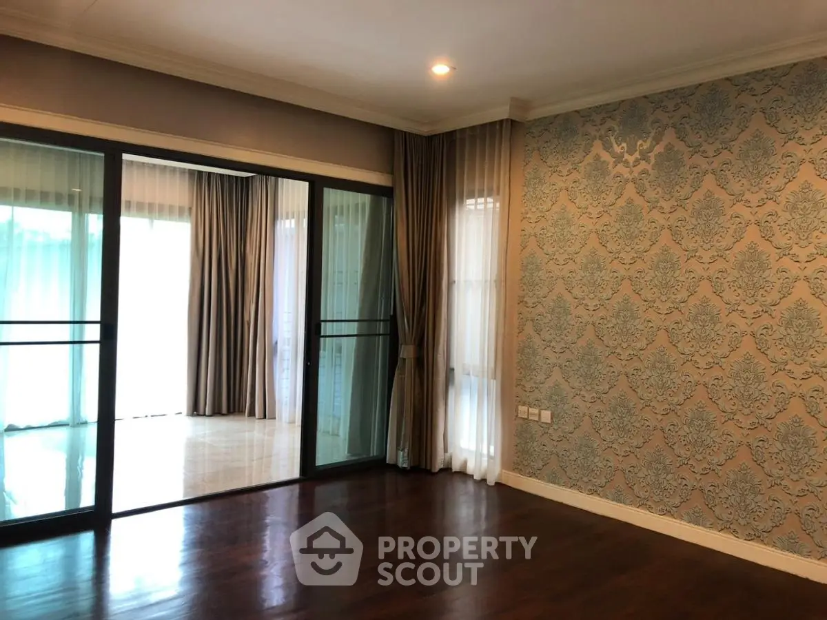 Spacious living room with elegant wallpaper and large sliding glass doors