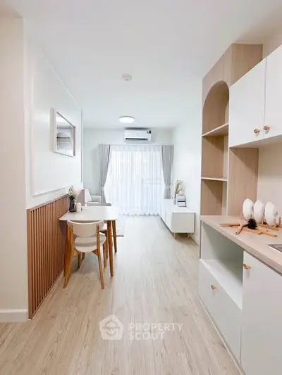 Modern open-plan living room with light wood flooring and minimalist decor.