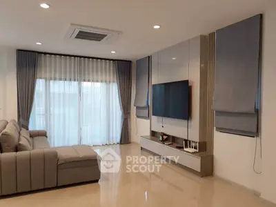 Modern living room with sleek design, large sofa, and wall-mounted TV, perfect for relaxation and entertainment.