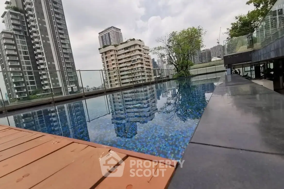 Luxurious rooftop pool with stunning city skyline views in modern high-rise building.