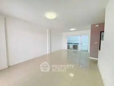 Spacious empty living room with large windows and glossy tiled floors