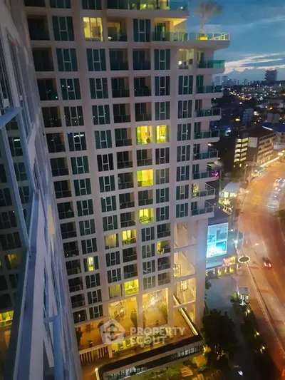 Stunning high-rise building with illuminated windows and cityscape view at dusk.
