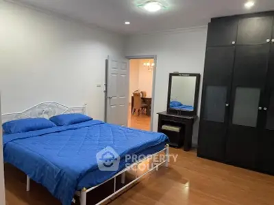 Spacious bedroom with modern furnishings and wooden flooring in a stylish apartment.