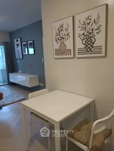 Modern living room with stylish decor and dining area, featuring elegant wall art and contemporary furniture.