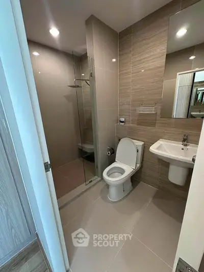 Modern bathroom with glass shower and sleek fixtures in a contemporary apartment.