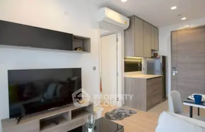 Modern living room with sleek furniture and open kitchen layout in a stylish apartment.