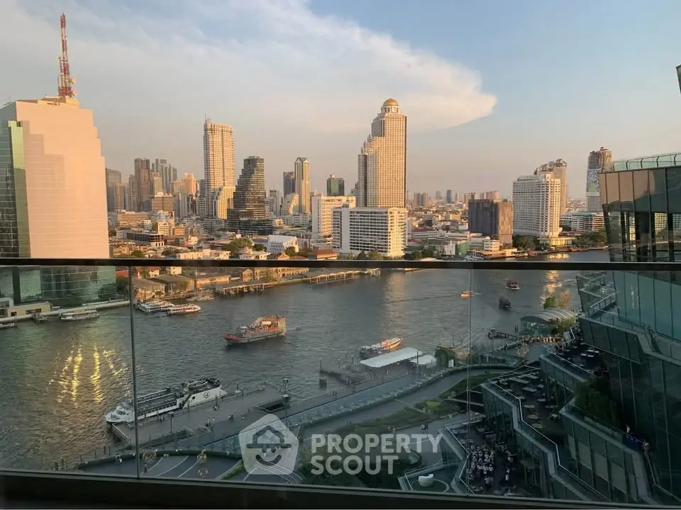 Stunning cityscape view from a high-rise balcony overlooking a river and skyline.