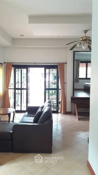 Spacious living room with large windows and cozy seating area