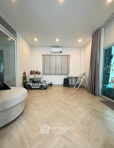 Spacious living room with modern decor and natural light, featuring a cozy sofa and sleek flooring.