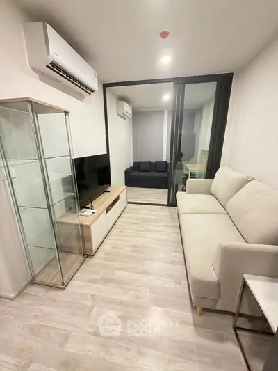Modern living room with glass cabinet and cozy sofa in stylish apartment