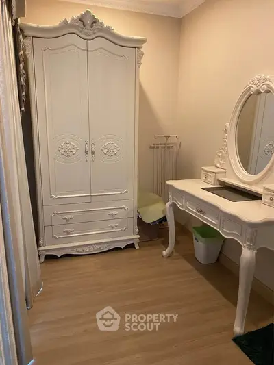 Elegant bedroom with classic white furniture and wooden flooring