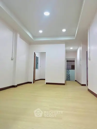 Spacious interior with modern lighting and wooden flooring, ideal for versatile living space.