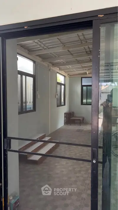 Spacious enclosed patio with sliding glass doors and tiled flooring, perfect for relaxation or entertaining guests.