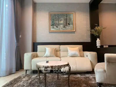 Elegant living room with plush sofa, stylish rug, and serene wall art, perfect for relaxation.