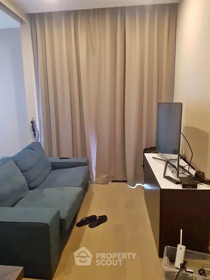 Cozy living room with blue sofa and modern TV setup, perfect for relaxation.