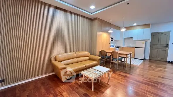 Modern living room with open kitchen and stylish wood paneling