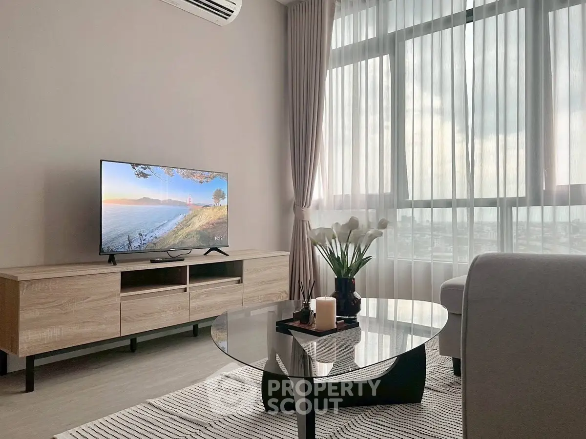 Modern living room with large window, stylish furniture, and natural light.