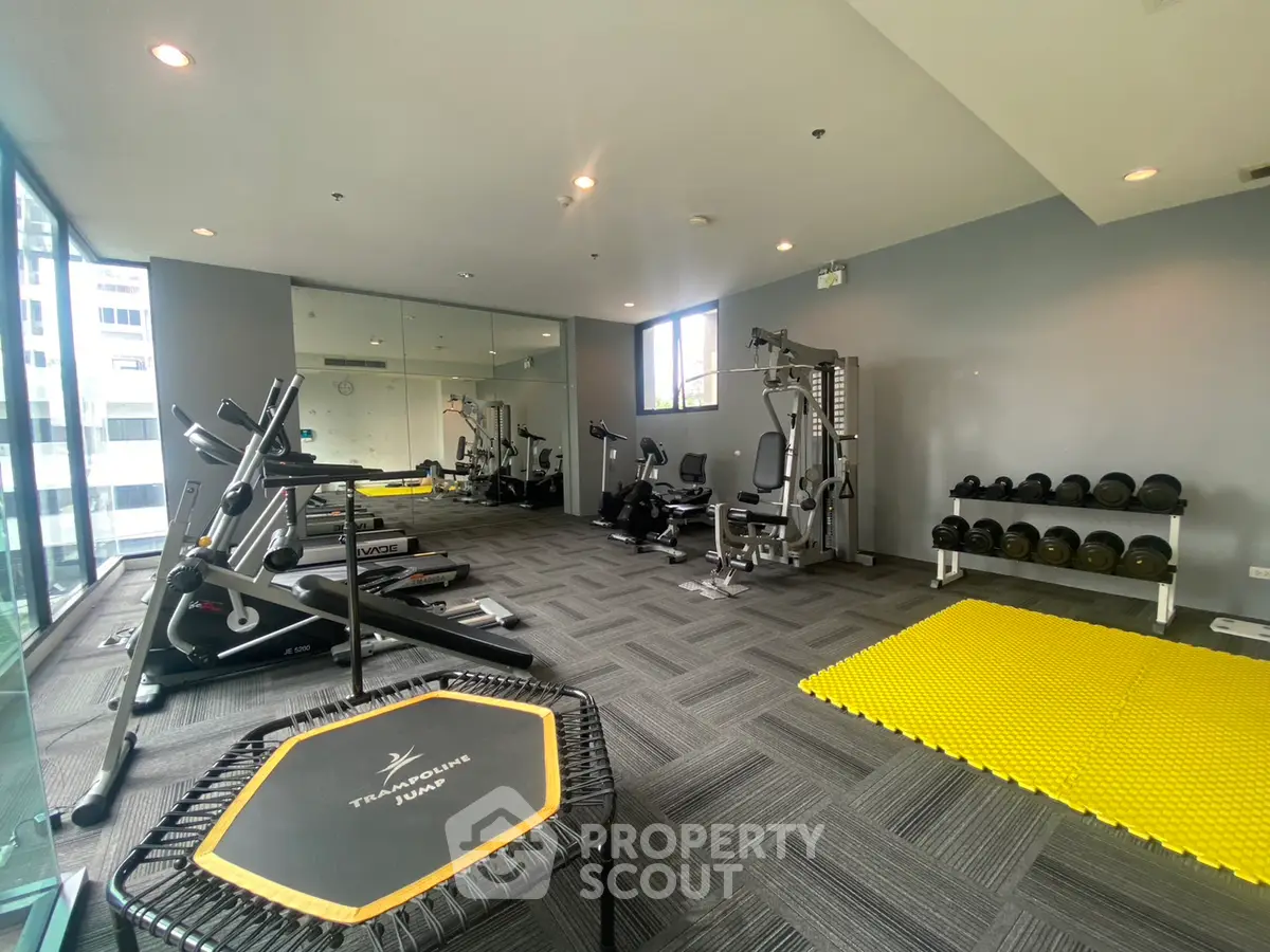 Modern gym with state-of-the-art equipment and spacious layout in a residential building.