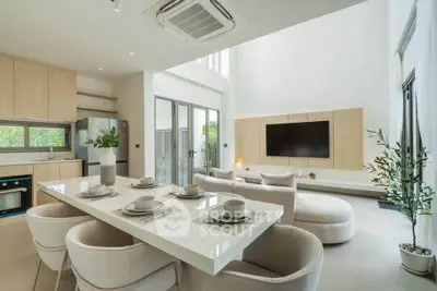 Luxurious modern living room with open kitchen, high ceilings, and elegant decor.
