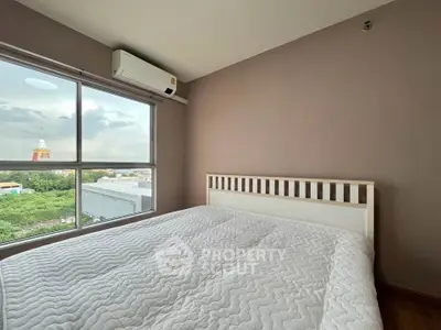 Spacious bedroom with large window offering scenic views and modern air conditioning.