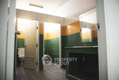 Modern bathroom with green and orange tiles, featuring a clean and spacious layout.