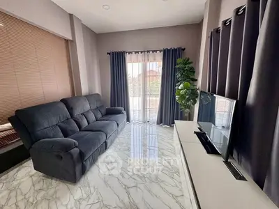 Modern living room with marble flooring, plush sofa, and large TV setup.