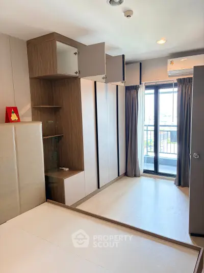 Modern bedroom with built-in storage and balcony view in a stylish apartment.