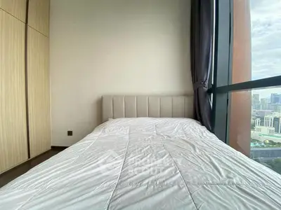 Modern bedroom with city view and large window, featuring a cozy bed and built-in wardrobe.